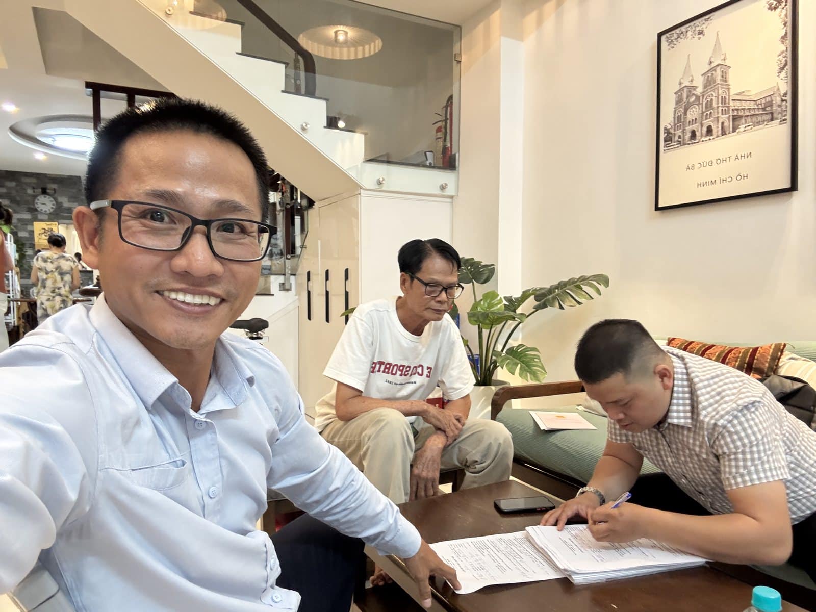 Lê Hoàng Giang cùng khách ký giấy tờ mua bán nhà
